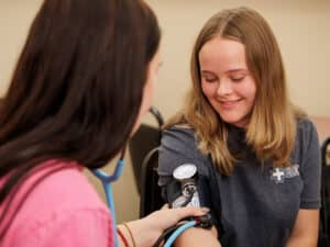 Sharon School of Nursing students taking blood pressure measurements.